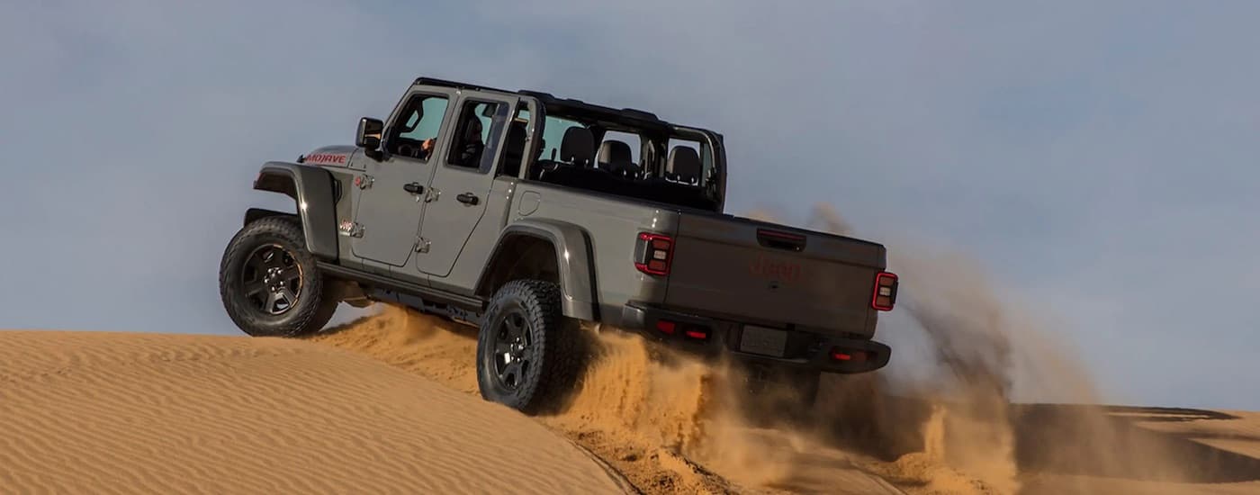 A grey 2023 Jeep Gladiator Mojave is shown from the rear at an angle.
