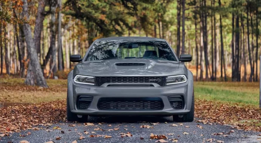 A grey 2023 Dodge Charger SRT Hellcat is shown parked near autumn leaves.
