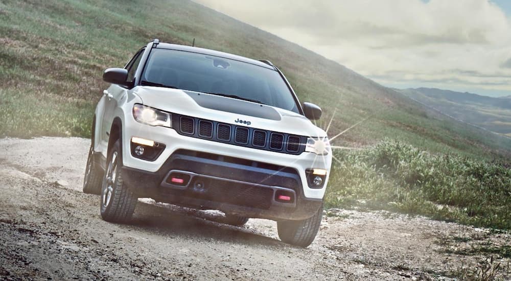 A white 2020 Jeep Compass TrailHawk is shown from the front after leaving a used Jeep dealer.