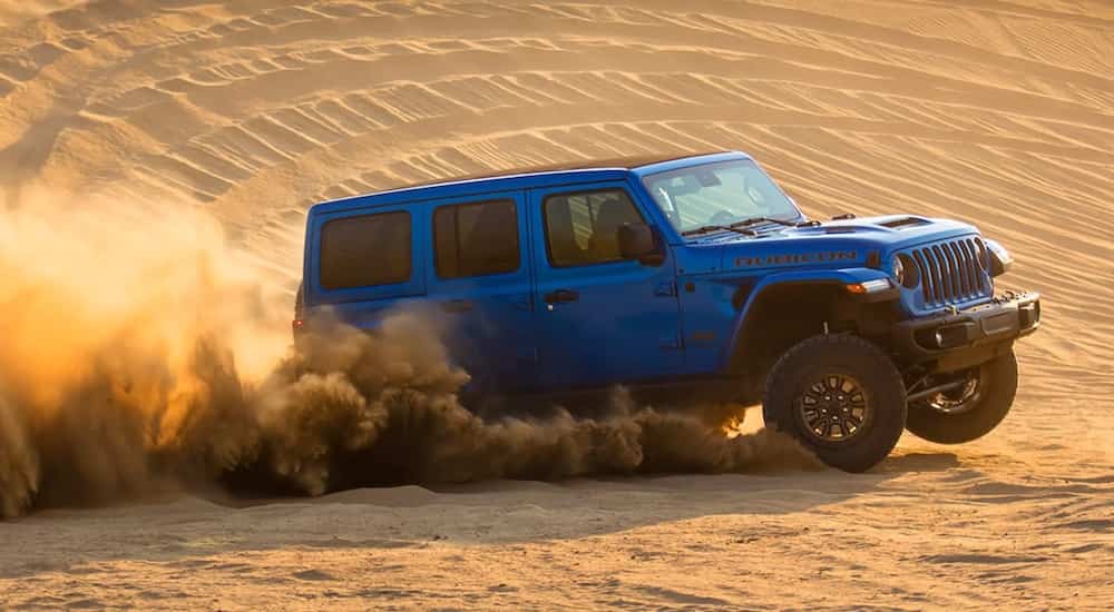 A blue 2021 Jeep Wrangler Rubicon 392 is shown from the side after leaving a used Jeep dealer.