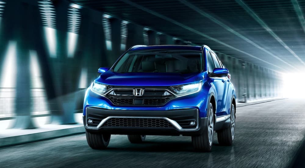 A blue 2020 Honda CR-V Touring driving in a tunnel.