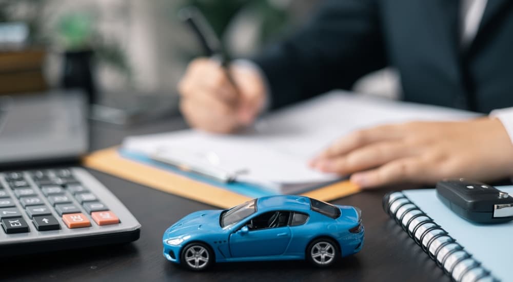 Close-up of a blue toy car sitting on a desk at a dealer with used cars for sale near Eureka.
