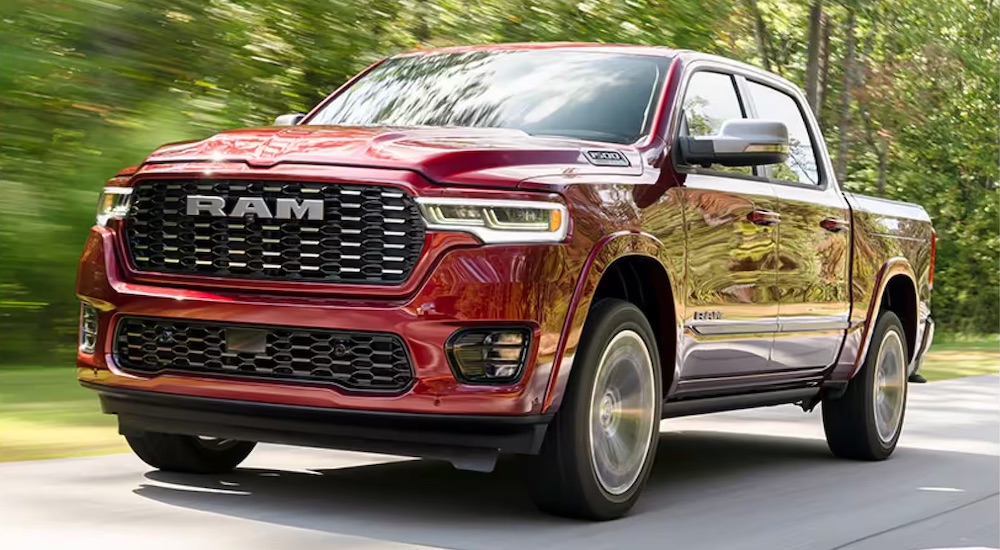 Red 2025 Ram 1500 driving down a road.