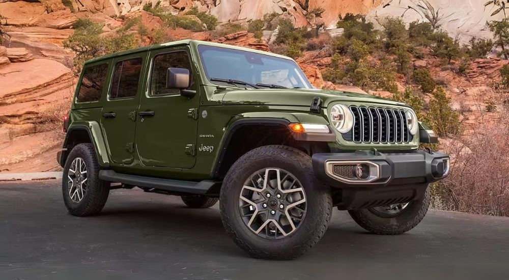A green 2024 Jeep Wrangler Sahara Unlimited parked off-road