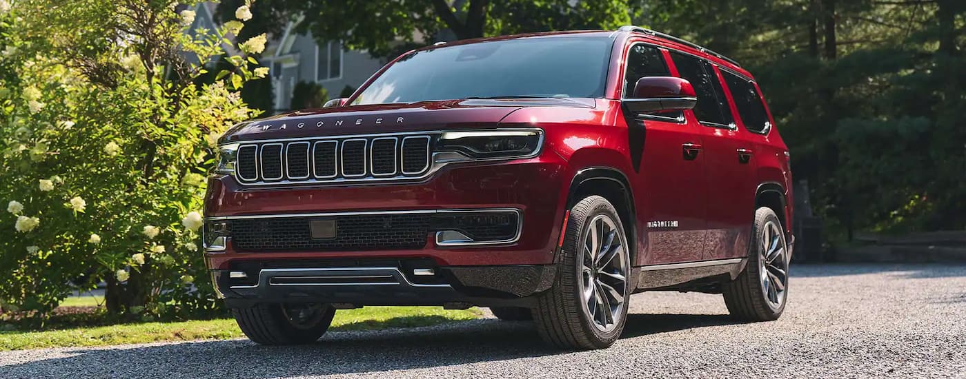 A red 2023 Jeep Wagoneer parked on a driveway after visiting a Jeep dealer.