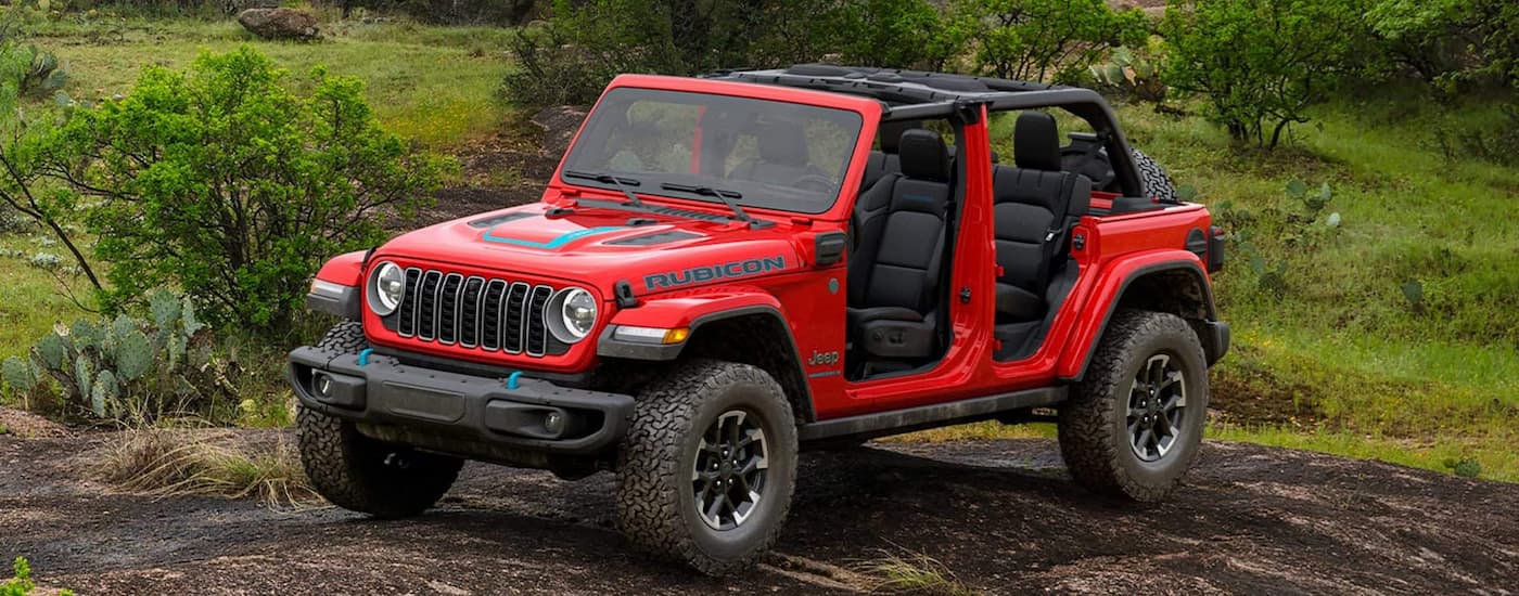 Red 2025 Jeep Wrangler Rubicon 4xe for sale near Peoria parked off-road.