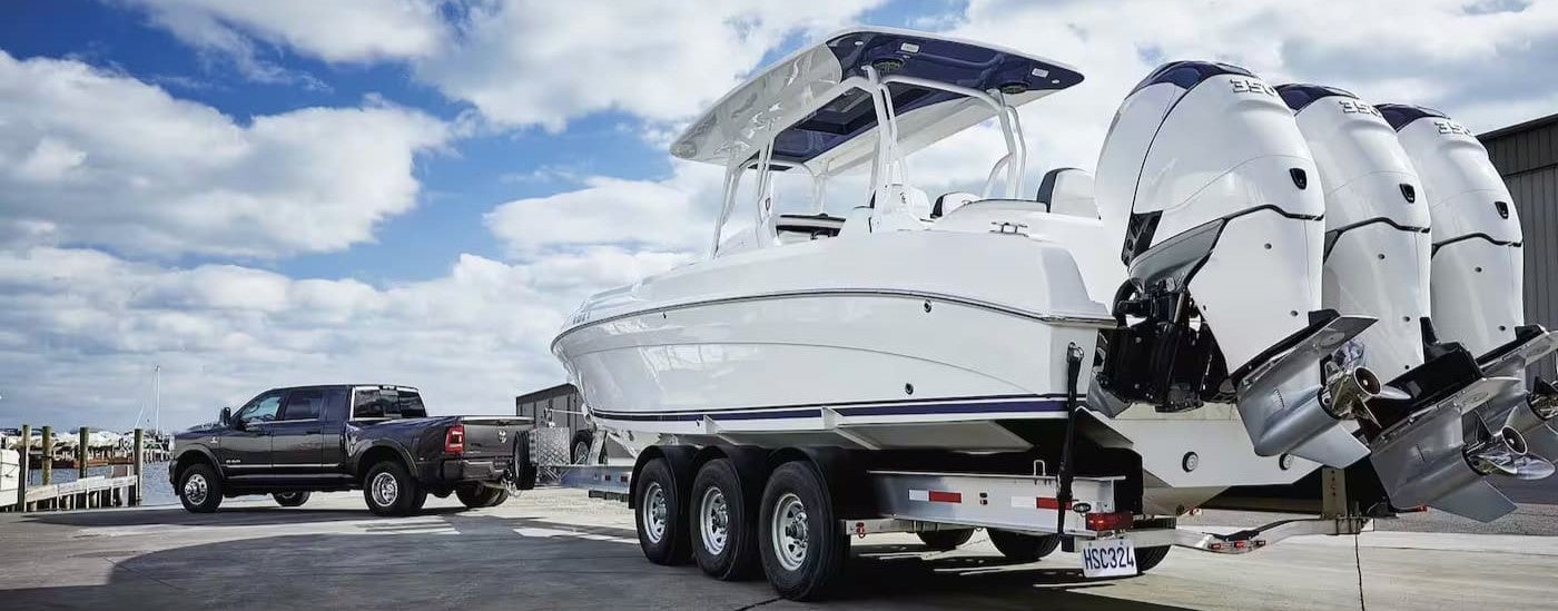 Rear view of a black 2024 Ram 3500 towing a boat.