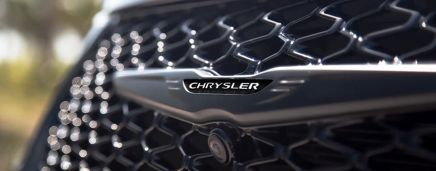 Close-up of the Chrysler badge on the front grille of a 2025 Chrysler Pacifica